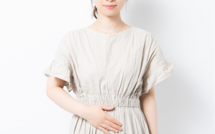 お腹に手を当てる女性